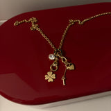 Gold necklace with charms on a red surface