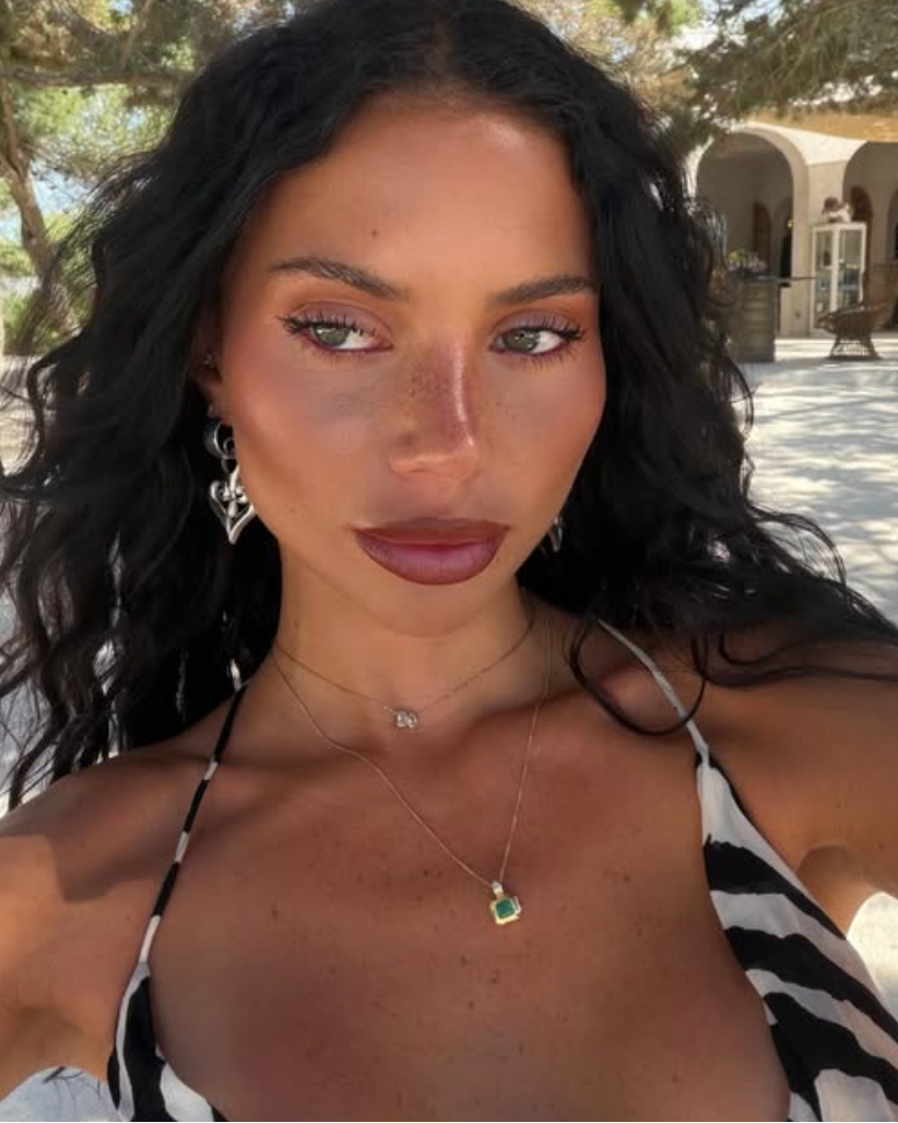 Woman with dark hair and a black and white striped top outdoors