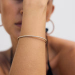 Woman wearing a Diamond Tennis Bangle on a white background