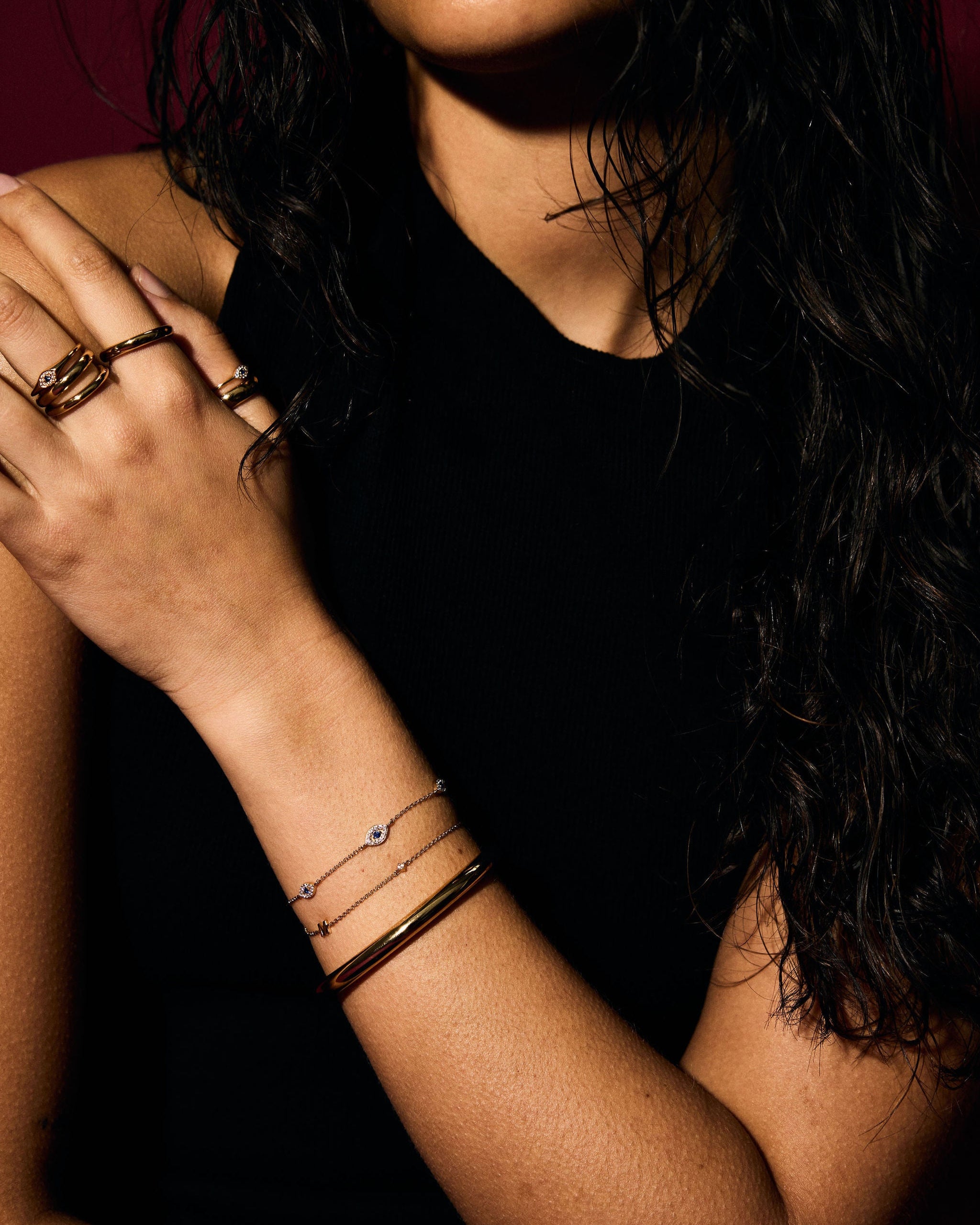 Close-up of a person's arm with multiple evil eye bracelets and rings
