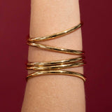 Gold bracelet on a wrist against a red background