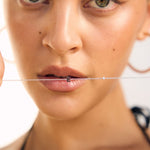 Close-up of a woman's face with a Sterling silver letter bracelet
