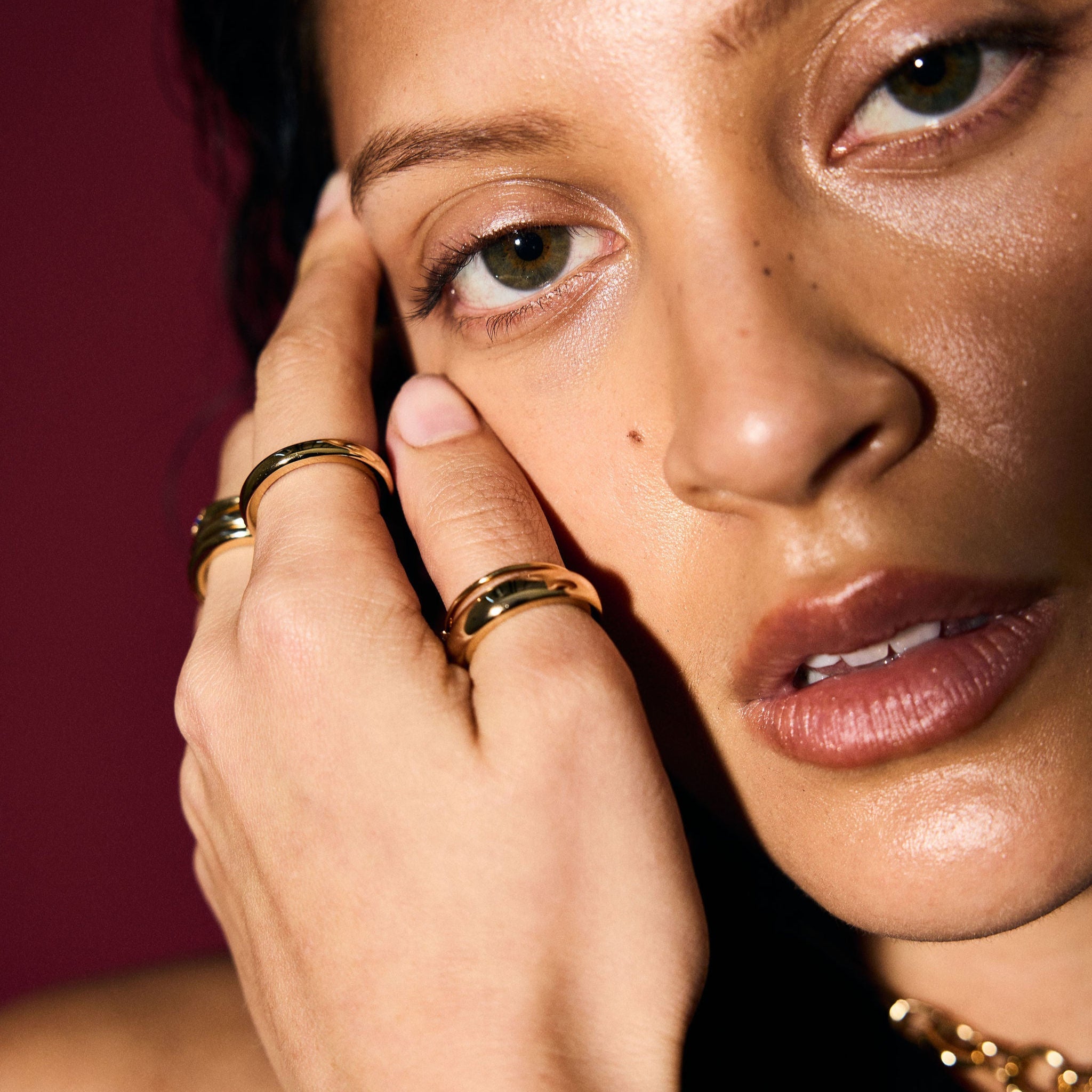 Close-up of a woman's face with jewelry on a dark background