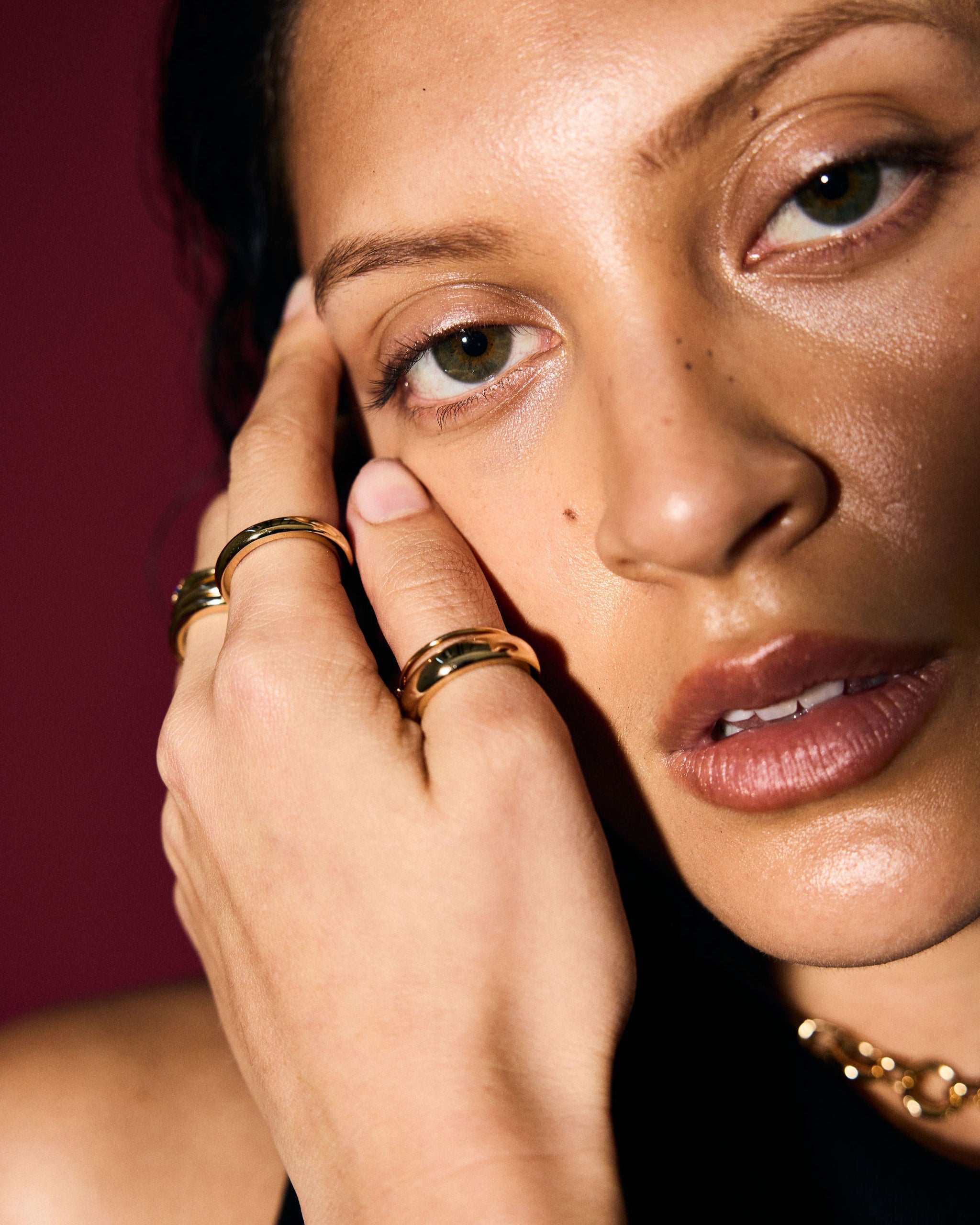 Close-up of a woman's face with jewelry on a dark background