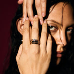 Close-up of a person's hand with an evil eye signet ring, focusing on the jewellery.