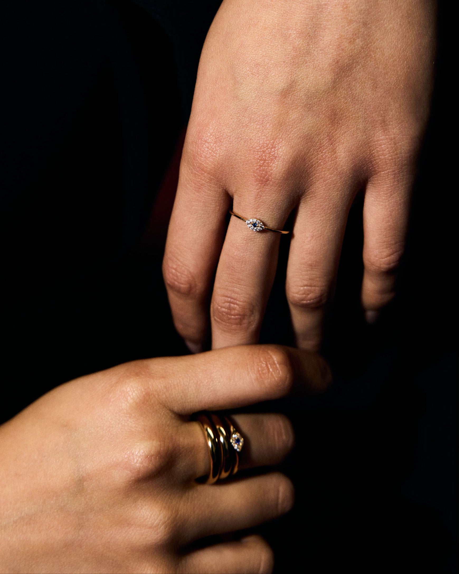 Close-up of a person's hand with a petite evil eye ring