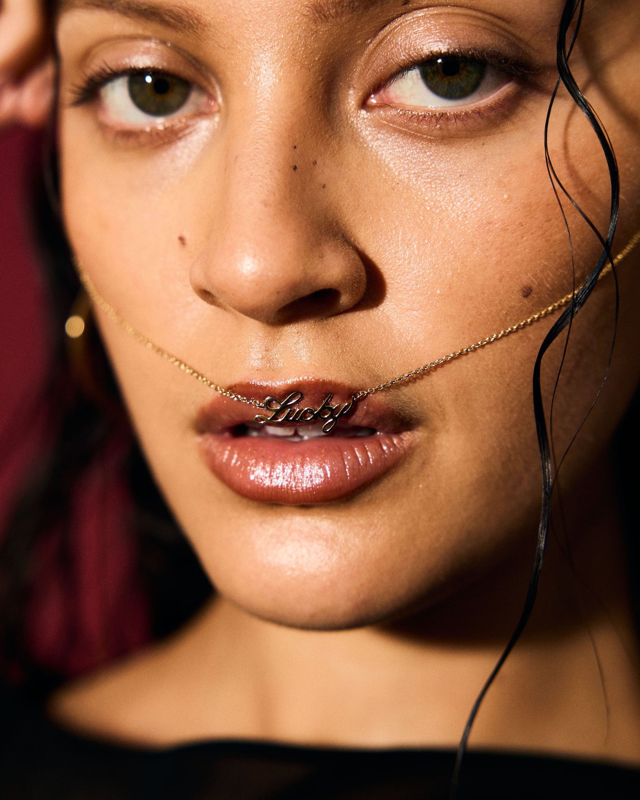 Close-up of a woman's face with a gold chain around her neck.