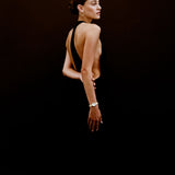 Woman wearing a black dress with a deep neckline against a dark background