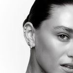 Close-up of a person wearing earrings with a white background