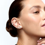 Close-up of a woman wearing diamond earrings with a neutral background