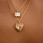 Gold necklaces with heart-shaped and star pendants on a skin background