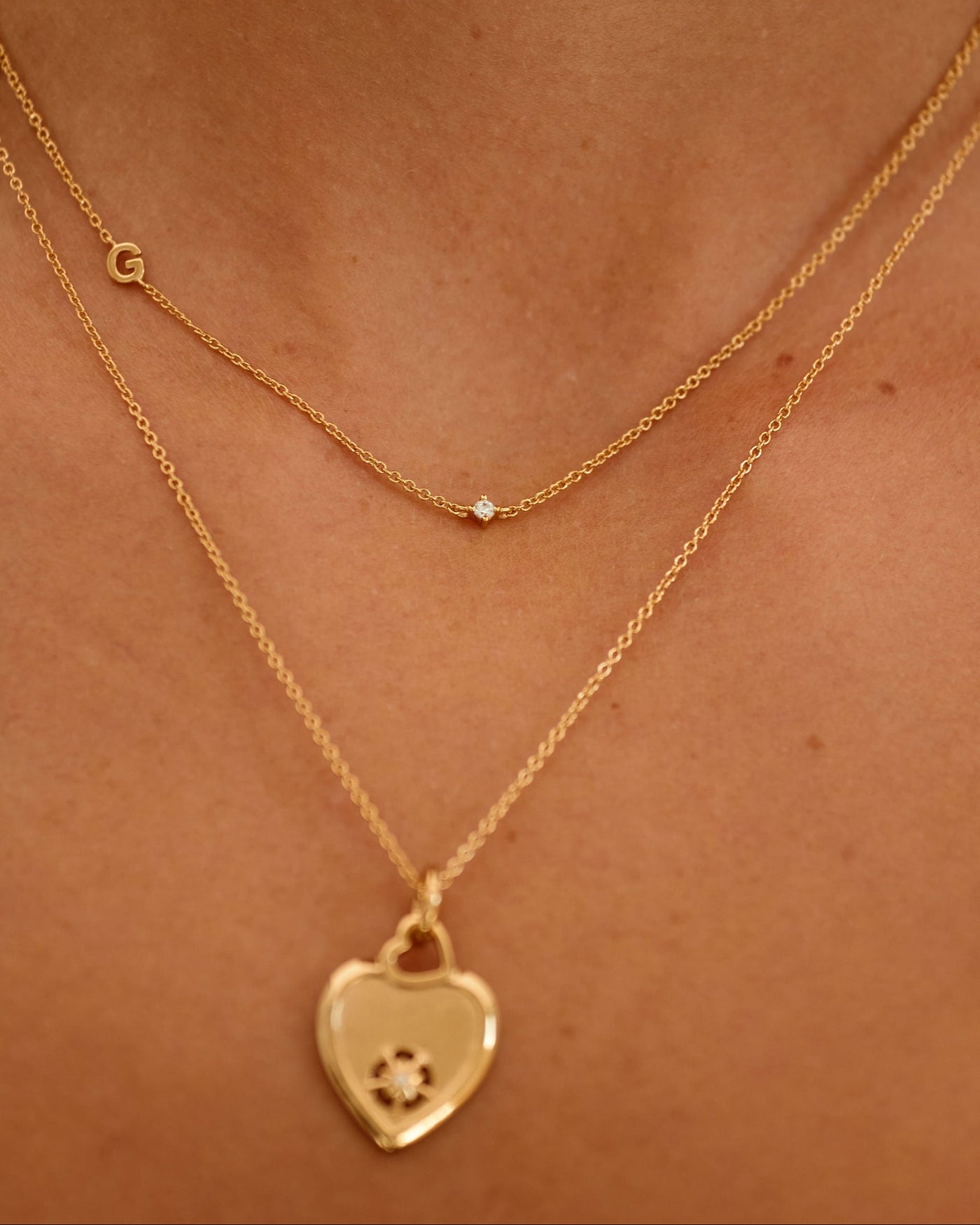 Gold necklace with a heart-shaped pendant on a person's neck