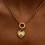 Gold necklace with a heart-shaped pendant on a person's neck