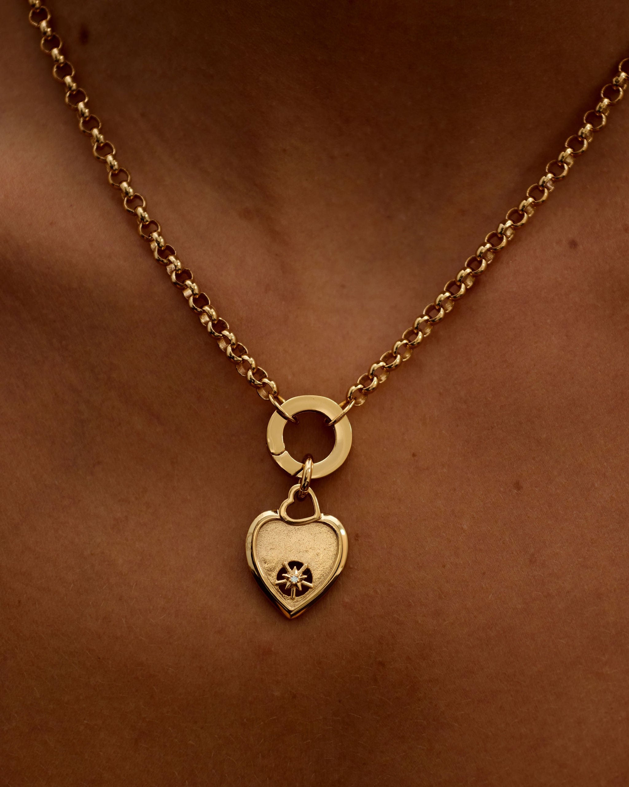 Gold necklace with a heart-shaped pendant on a person's neck