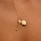 Gold necklace with heart and key pendants on a person's neck